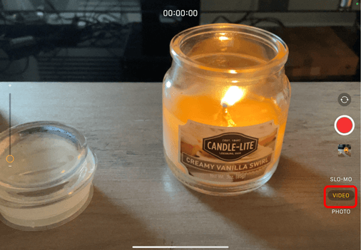 Camera on Ipad pointing at a candle with the Video button circled in red to show how to change Camera to video option