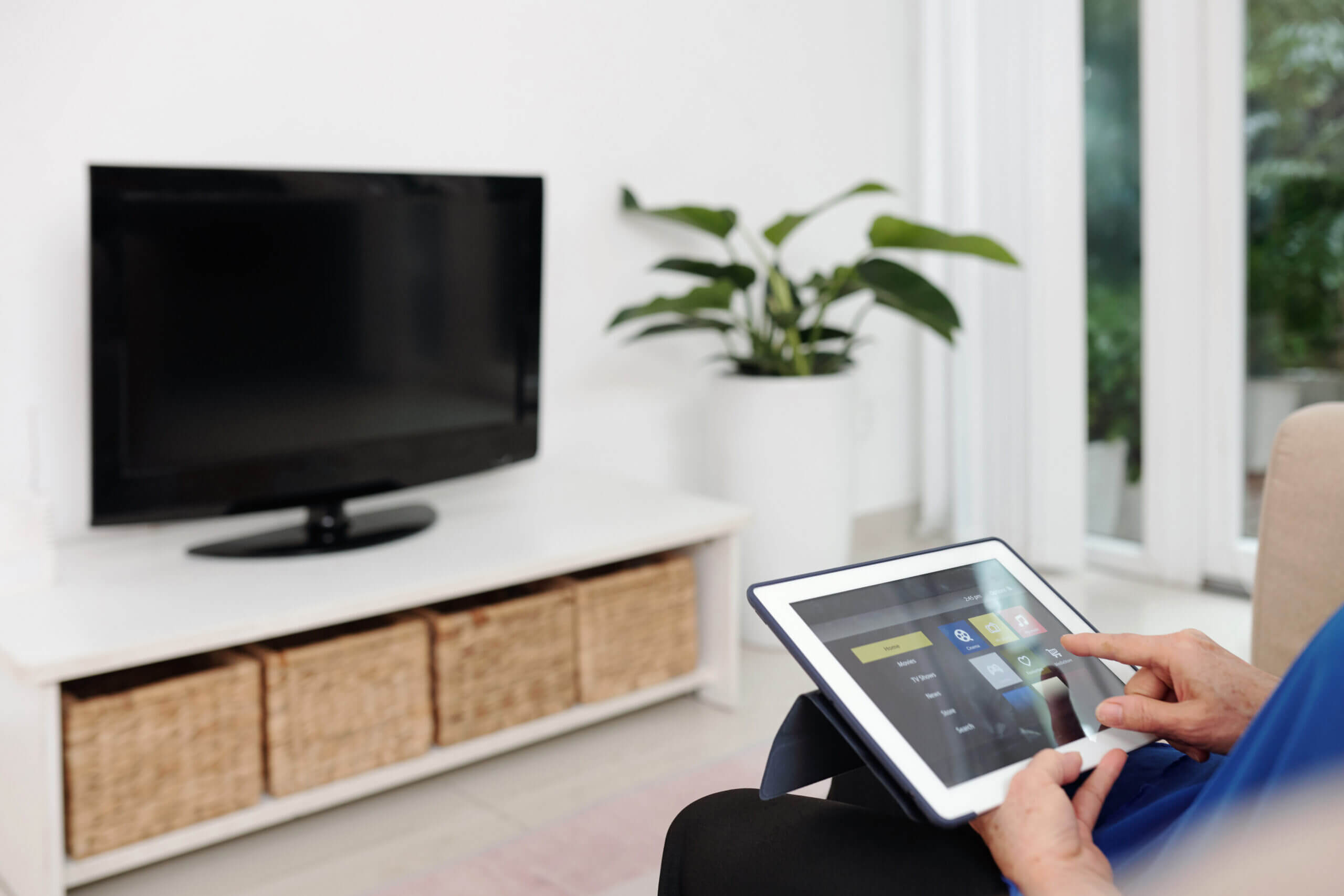Older woman sitting in living room using tablet
