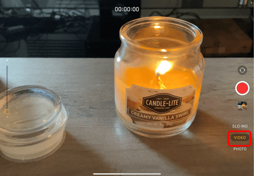 Camera on Ipad pointing at a candle with the Video button circled in red to show how to change Camera to video option
