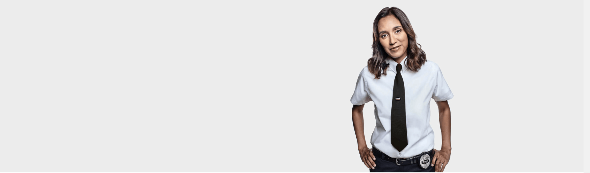 Image of a female Geek Squad Agent wearing a white short sleeve shirt and black tie.