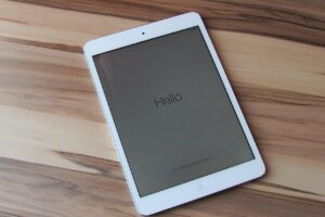 White iPad on table top with Hallo written across the screen.