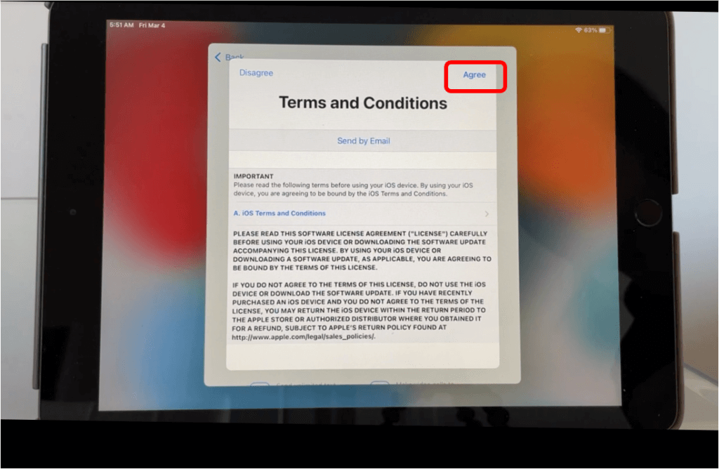 iPad screen with iOS Terms and Conditions and Agree button in top right corner circled in red